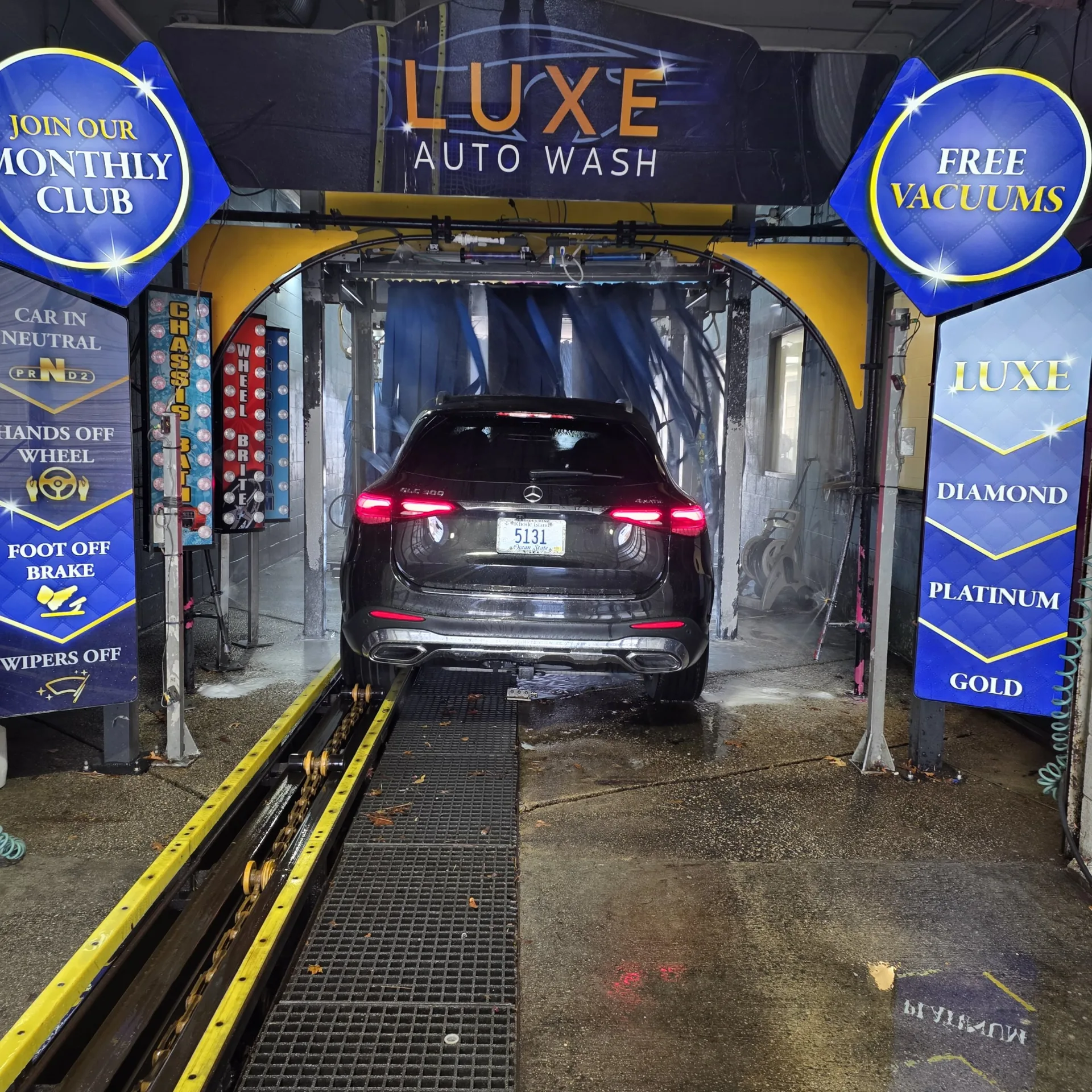 A car driving into the Luxe Auto Wash tunnel arch